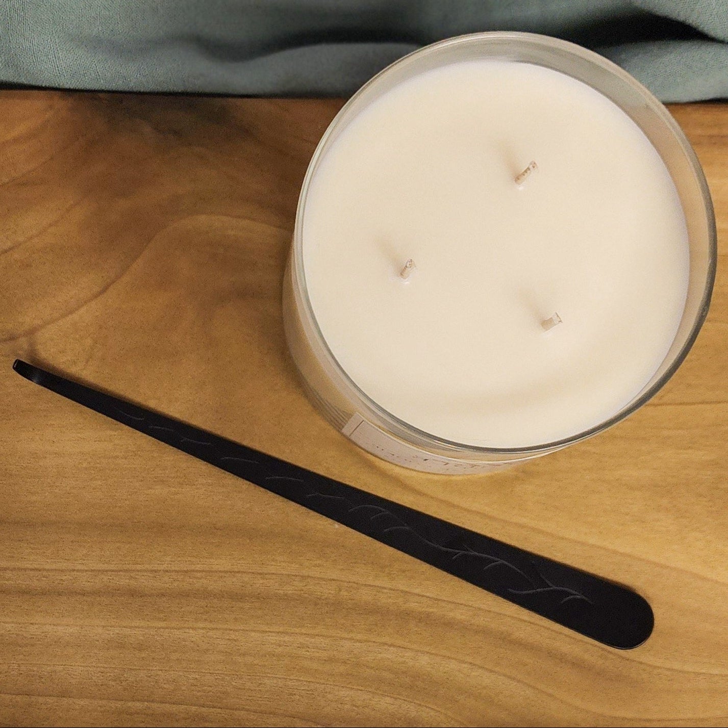 black wick dipper with candle on wood table