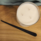 black wick dipper with candle on wood table