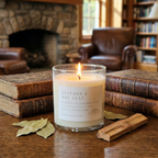 Leather Bay Leaf candle on wood surface with leather bound books